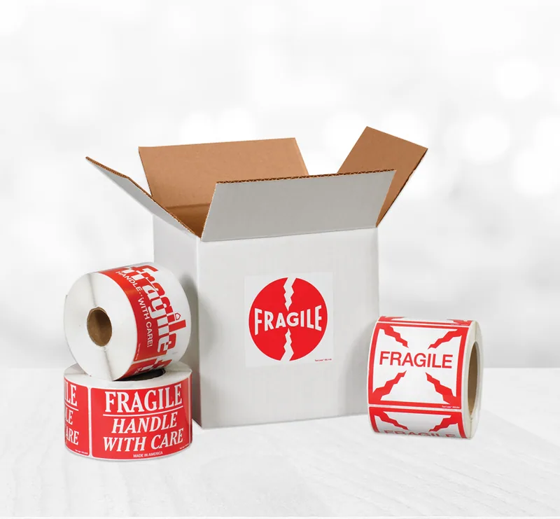 Fragile labels on rolls next to an open white box with a Fragile label
